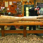 David Hostetler carving a reclining female wood sculpture in his studio